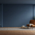 Modern interior of living room with leather armchair on wood flooring and dark blue wall- 3D rendering